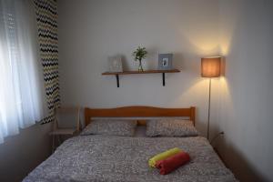 a bedroom with a bed with two pillows and a lamp at Apartment Optimist/Downtown in Split