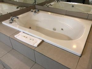 Fairview的住宿－迪爾菲爾德汽車旅館及套房- 費爾維尤，浴室内设有大型白色浴缸。