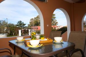 a table with a tray of food on a balcony at Yiouli Holiday Home in Acharavi