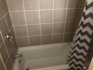 a bathroom with a white bath tub with a shower curtain at Beachway Motel in Salisbury