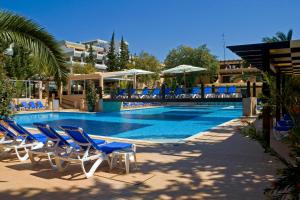 una piscina con sillas azules y una piscina en Apartamentos da Balaia, en Albufeira