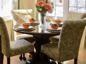 una mesa de comedor con sillas y un jarrón de flores en Stone Garden Inn, en Trenton