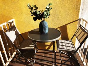 a table with a vase on it next to two chairs at Lisbon Central Apartment with Terrace in Lisbon