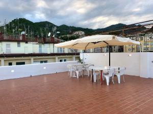 un patio con tavoli, sedie e ombrellone di Casa Vacanze Sunshine a Salerno