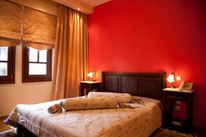 a red bedroom with a bed with a dog laying on it at Hotel Kynaitha in Kalavrita