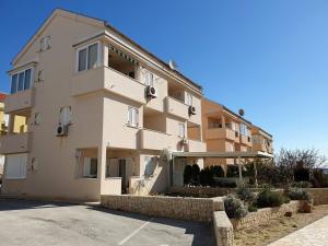 ein großes weißes Gebäude mit einem Parkplatz in der Unterkunft Apartment Blue Sky in Novalja + 11 Fotos