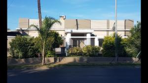 Don TorcuatoReal Horizonte Hotel -Motel-的前面有一条街道的白色建筑