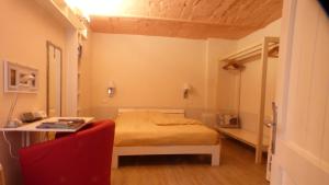 a small bedroom with a bed and a desk at Badia in Modena