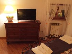 a bedroom with a television and a dresser with a bed at Moro Dal Castel - Appartamento Al Castel in Castelnuovo del Garda