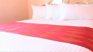 a bed with a red and pink chevron bedspread at Crystal Star Inn Edmonton Airport with free shuttle to and from Airport in Leduc