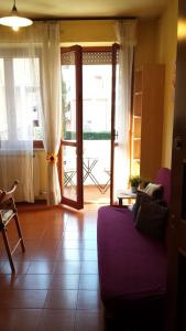 - un salon avec un canapé violet et une porte coulissante en verre dans l'établissement WelcHome - Cisanello, à Pise
