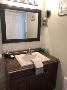 y baño con lavabo y espejo. en By The Sea Tourist Home, en Bonavista