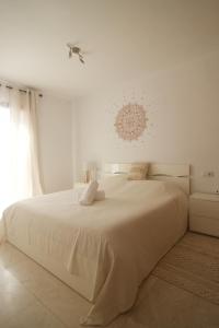 a white bedroom with a large bed and a window at Royal Park Guesthouse in Corralejo