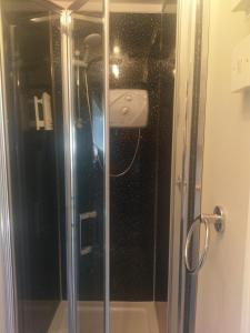 y baño con ducha y puerta de cristal. en Gallery Guest House, en Plymouth