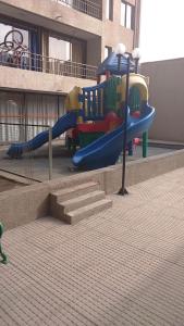 a playground with a slide in front of a building at Departamento A Pasos de Metro Ñuble in Santiago