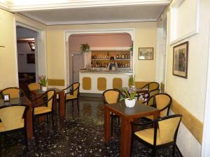 a restaurant with tables and chairs and a bar at Hotel Ariston Montecarlo in Sanremo