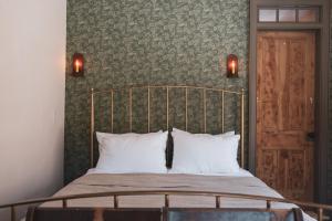 a bed with two white pillows and a green wall at Stonehill's Farmhouse in Accord