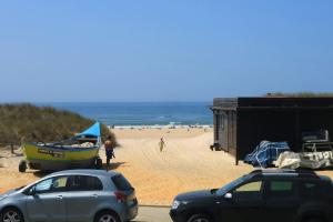 two cars parked on a beach with a boat at Palheiro da Tocha in Tocha