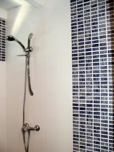 a shower with a glass tile wall in a bathroom at Bungalows MALUEVA in Sainte-Anne
