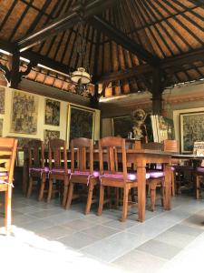 a dining room with a wooden table and chairs at Nirvana Pension in Ubud