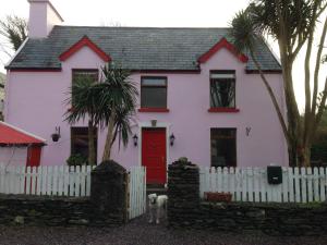 a white house with a dog in front of it at The Old Barracks,Caherdaniel in Caherdaniel