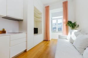 een witte woonkamer met een witte bank en een raam bij Urban Jungle in Lissabon