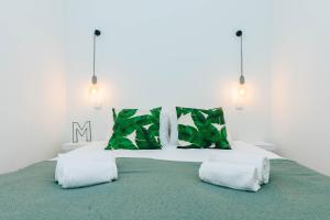 ein Schlafzimmer mit einem großen grünen Bett mit zwei Kissen in der Unterkunft Urban Jungle in Lissabon