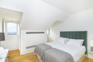 een witte slaapkamer met een groot bed en een raam bij Velvet Dream Apartment in Lissabon