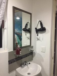 a bathroom with a sink and a mirror and a camera at Apartamento privado, NUEVO Rooftop, AC, GRAN WF in Cancún