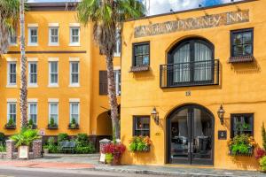 żółty budynek z palmami przed nim w obiekcie Andrew Pinckney Inn w mieście Charleston