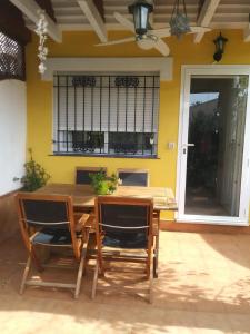 a dining room table and chairs with a yellow wall at Casa en el Centro de Cabo de Palos Cerca a Clubes de Buceo in Cabo de Palos