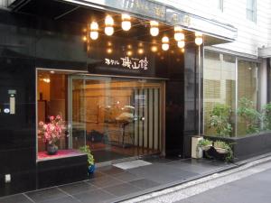 un negozio di fronte a un edificio con finestra di Hotel Kizankan a Tokyo