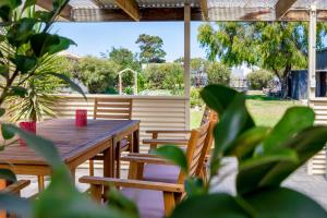 a wooden table and chairs on a patio at Agnes Cottage Bed & Breakfast in Kingston South East