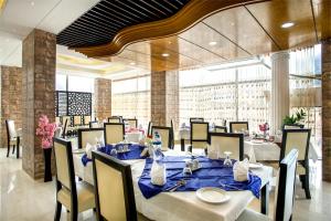 a dining room with white tables and chairs and a large window at White Palace Hotel in Dhaka