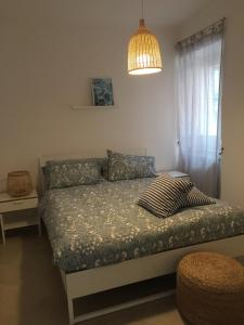a bedroom with a bed with a lamp and a window at Casa Levante in Gaeta