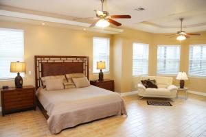 a bedroom with a bed and a chair and a ceiling fan at Villagoona in Cape Coral