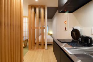 a kitchen with a stove and a bed in a room at T-home in Tokyo