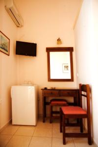 um quarto com um frigorífico, uma mesa e um espelho em Avra Hotel em Tinos