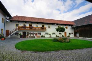 a large white house with a patio and a yard at Dienbergerhof 5 Sterne Ferienwohnungen in Untergriesbach