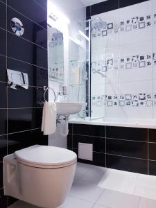 a bathroom with a toilet and a sink and a shower at Dream Apartment Brasov - West in Braşov +28 photos