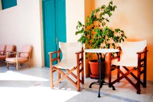 a table and two chairs and a potted plant at Avra Hotel in Tinos