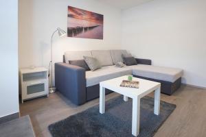 uma sala de estar com um sofá e uma mesa em apartman Fuerte 1 em Belgrado