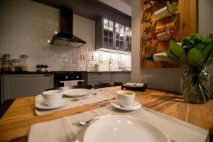 uma cozinha com um balcão com duas chávenas e um lavatório em The Golfer Apartment with Jacuzzi em Cluj-Napoca