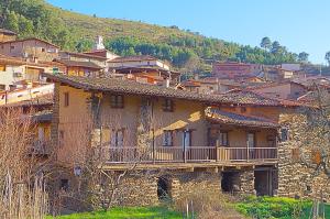 um edifício antigo com uma varanda numa montanha em Los Balcones del Río em Robledillo de Gata