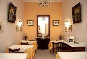 a restaurant with tables and chairs and a mirror at Avra Hotel in Tinos