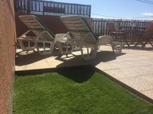 une paire de chaises longues assises sur une terrasse dans l'établissement Salitre, à La Caleta