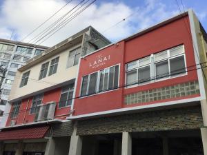 ein rotes Gebäude mit Schrift auf der Seite in der Unterkunft ラナイ ホテルアンドドミトリー in Naha
