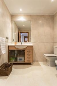 a bathroom with a sink and a toilet and a mirror at APARTAMENTO EN PRIMERA LINEA DE PLAYA RiAZOR in A Coruña