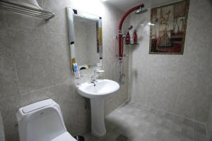 a bathroom with a sink and a toilet and a mirror at Jeonju Hotel in Jeonju