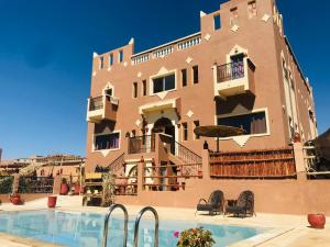 a building with a swimming pool in front of a building at Riad Dar Bab Todra in Tinerhir